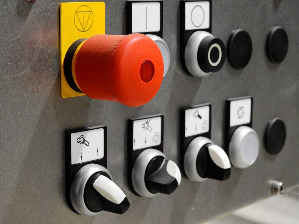 Not-Aus Schalter an einer Maschine als Beispiel für Sicherheitseinrichtungen im Maschinenbetrieb